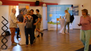 Menschen an Stehtischen, die sich auf dem Markt der Möglichkeiten informieren