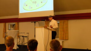 Dr. Erich Pick steht auf der Bühne und hält einen Vortrag zu Energiesystemen & Bürgerbeteiligung 